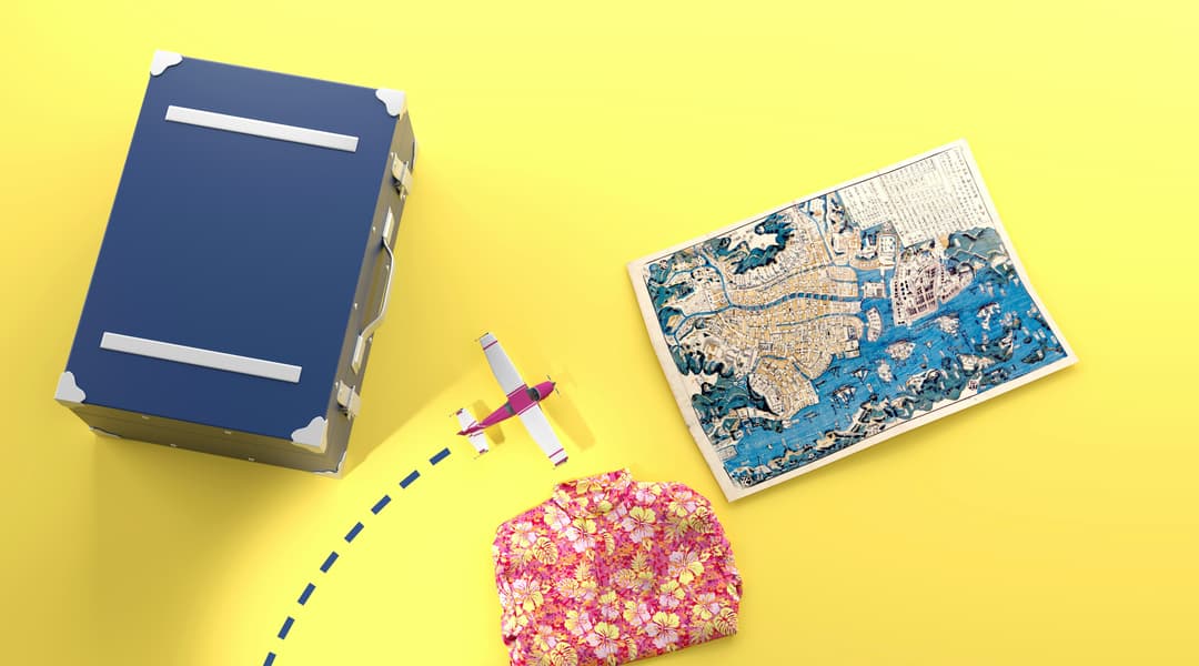 A travel suitcase, a piece of paper and a pair of scissors on a yellow background